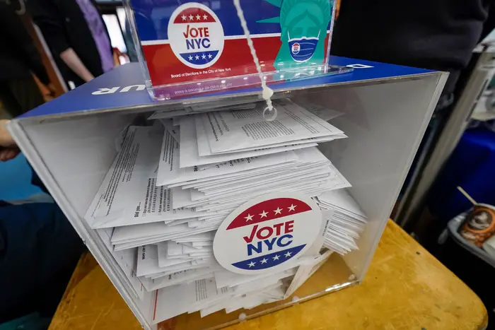 A box filled with absentee ballots (it's clear on one side, with a VOTE NYC sticker) at the Park Slope Armory